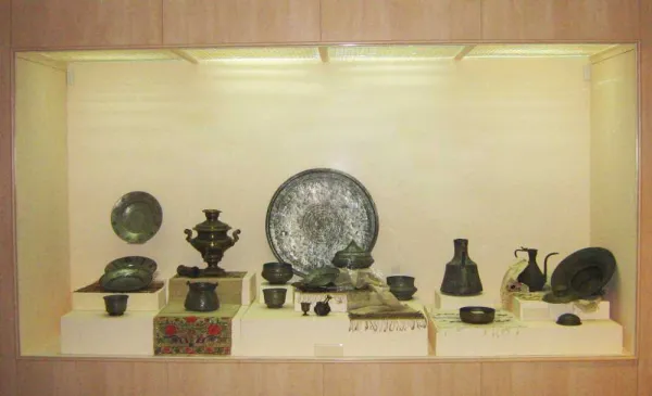 Müzede sergilenen tarihi metal eşyalar ve vitrin düzeni.