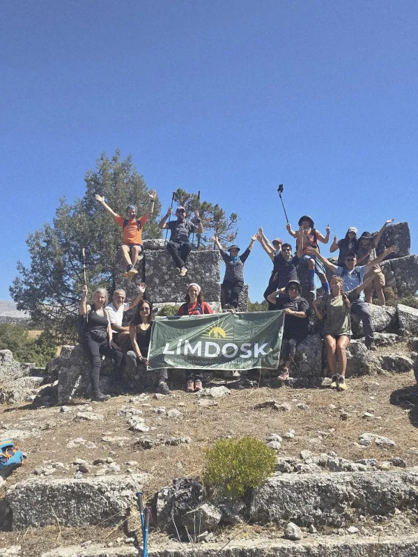 Zorzila Antik Kenti'nde ağaçlar önünde gülümseyen insanlar gruplar halinde poz veriyor.