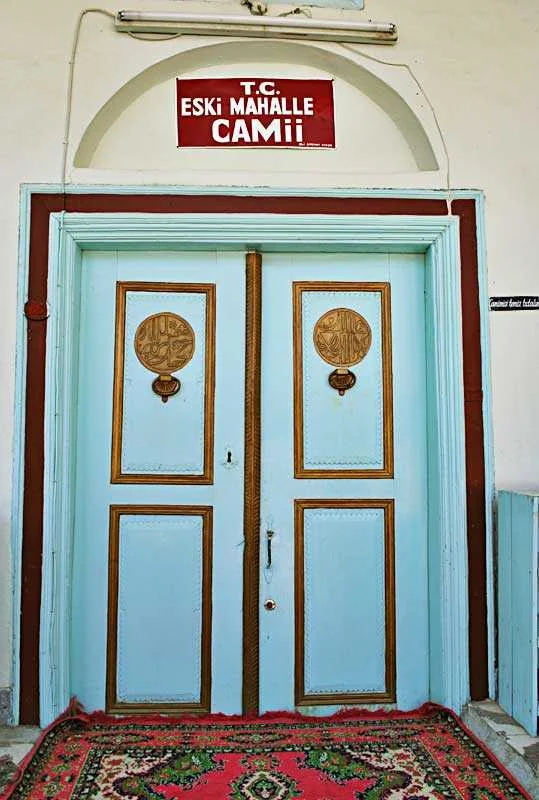 Açık mavi kapı ve altın detaylarla süslenmiş tarihi cami tabelası