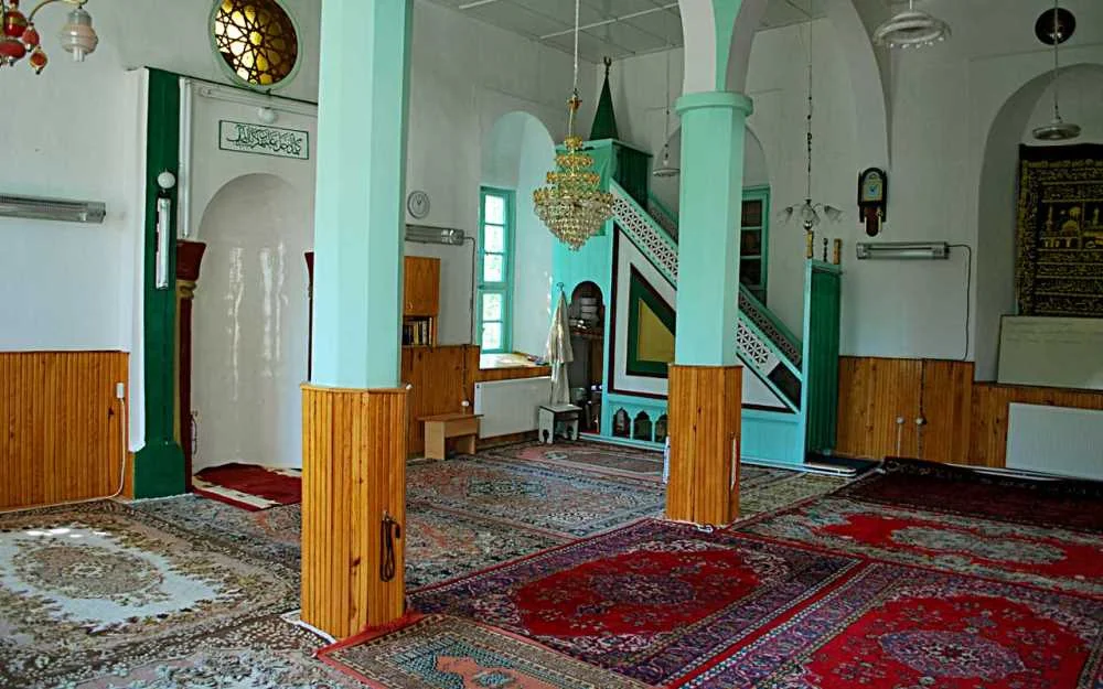 Geniş alan, yüksek tavan ve büyük sütunlarla cami iç mekanı
