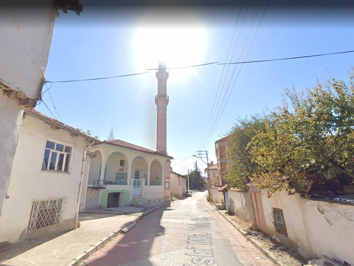 Küçük bir sokakta yükselen klasik mimarili cami minaresi