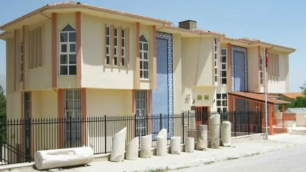 Modern iki katlı Uluborlu Müzesi, geniş pencereleri ve beyaz taş silindirlerle çevrili.