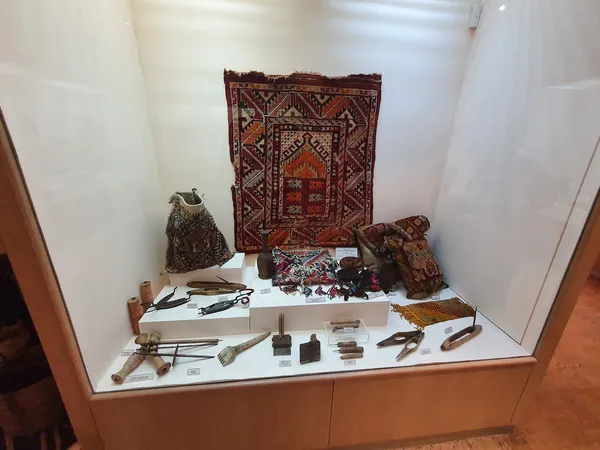Vitrinde sergilenen geleneksel el yapımı tekstil ürünleri ve zanaat malzemeleri.