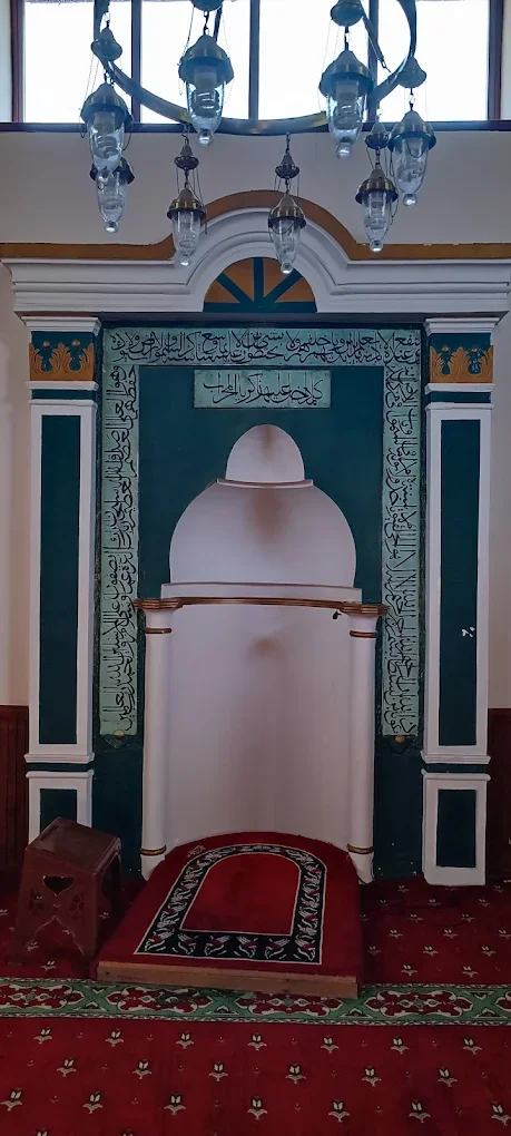 Yılanlıoğlu Camii iç mekanında süslü mihrab ve kırmızı halı