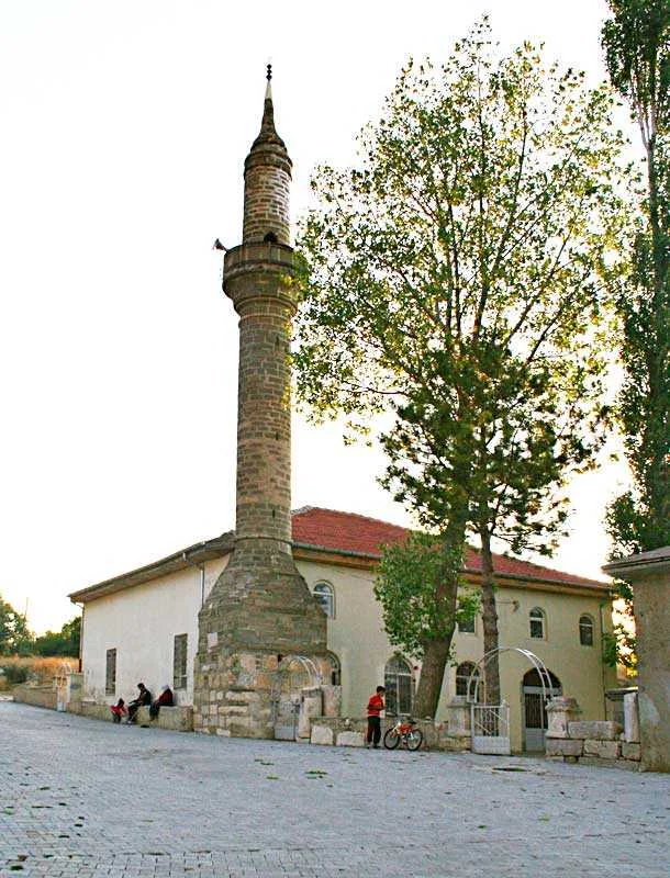 Taş yapılı Bülbül Camii ve ince minaresi, ağaçlar arasında huzurlu bir atmosfer sunuyor.