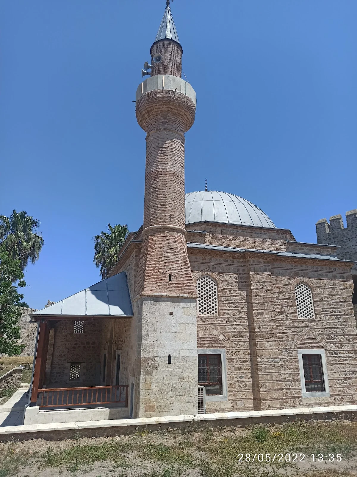Göz Alıcı Mimari: Minare ve Palmiye Ağaçları! Cami mimarisine sahip yapının yüksek minaresi ve çevresindeki palmiye ağaçları