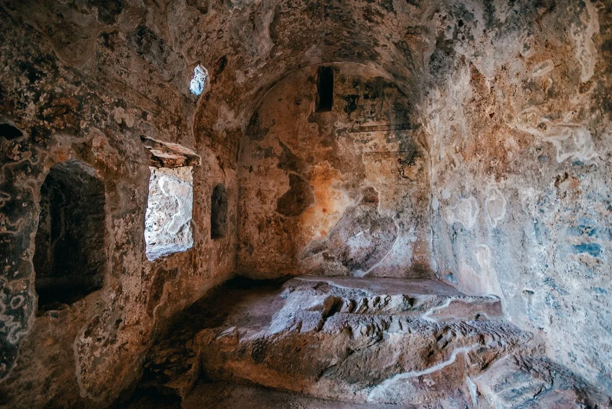 Taş duvarlarla çevrili, iç mekanda doğal ve tarihsel izler barındıran bir yapı.
