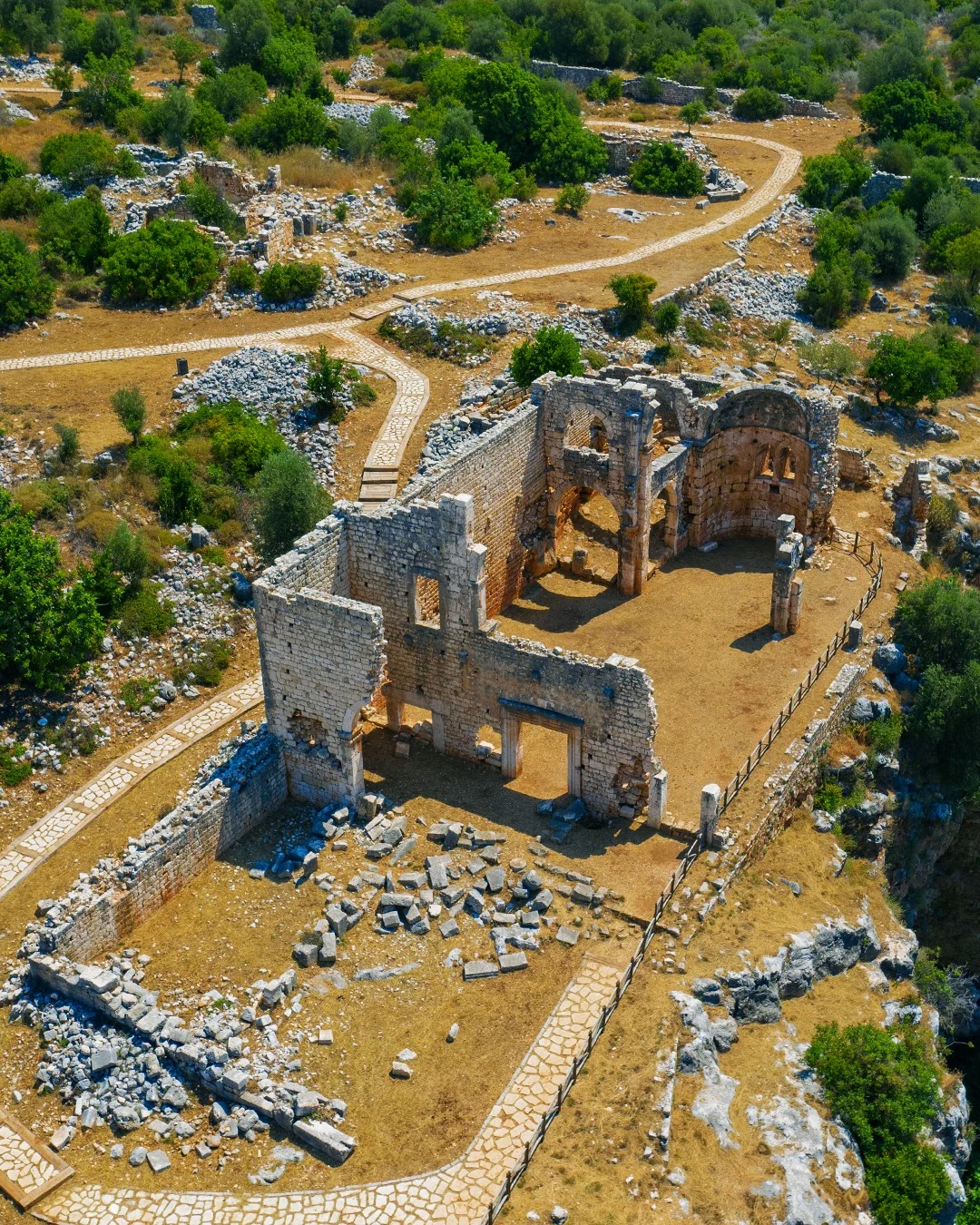 Tarihin İzleri - Geniş Açının Gücü Geniş bir doğal alanda harabe yapılar ve taş kalıntıları, yeşil bitki örtüsü ile sarı toprak rengi arasında yer