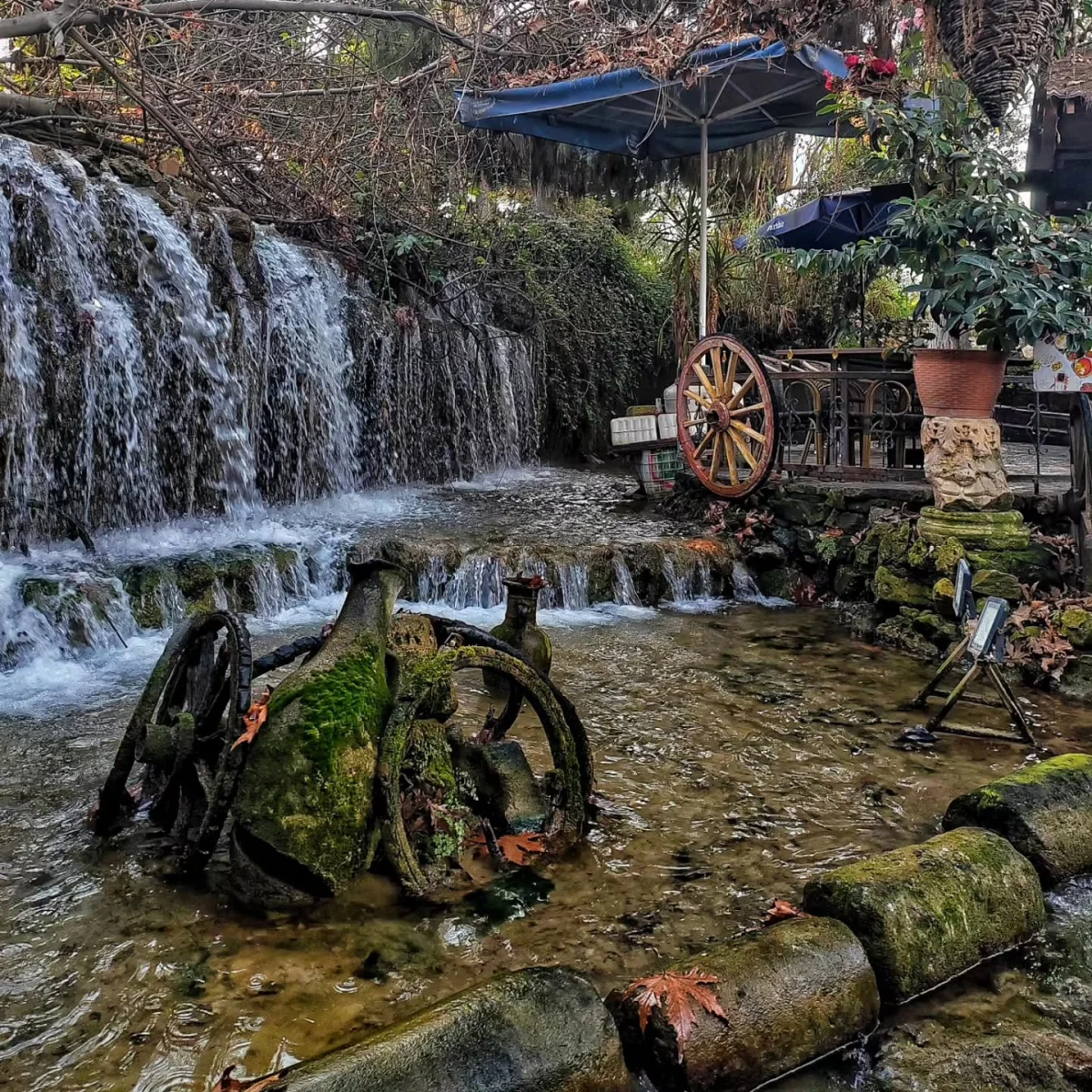 Tarsus Şelalesi'nin Huzur Verici Güzelliği - Akan Suyun Etrafında Dinlenme Tarsus şelalesinde akan suyun etrafında dinlenme alanı ve yosun kaplı metal parçaları