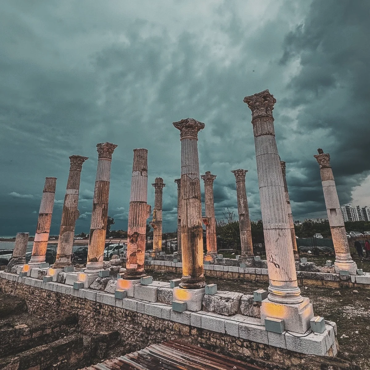 Soli Pompeipolis Antik Kenti'nin Tarihi Sütunları Antik sütunların hasar görmüş yüzeyleri ve karanlık gökyüzü ile dramatik bir manzara.