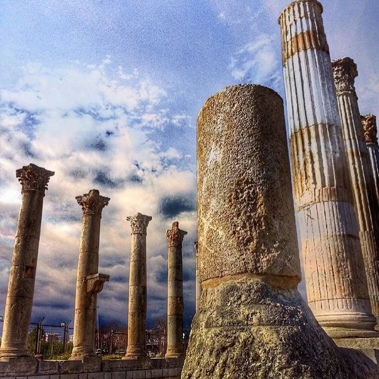 Soli Pompeipolis Antik Kenti'nin Tarihi Güzelliği Yüksek taş sütunlar arasında tarihi kalıntılar ve dramatik bulutlar