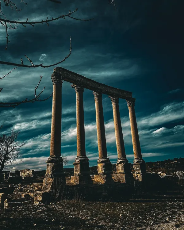 Beş yüksek sütun, karanlık bulutlar arasında tarihi bir atmosfer sunuyor.