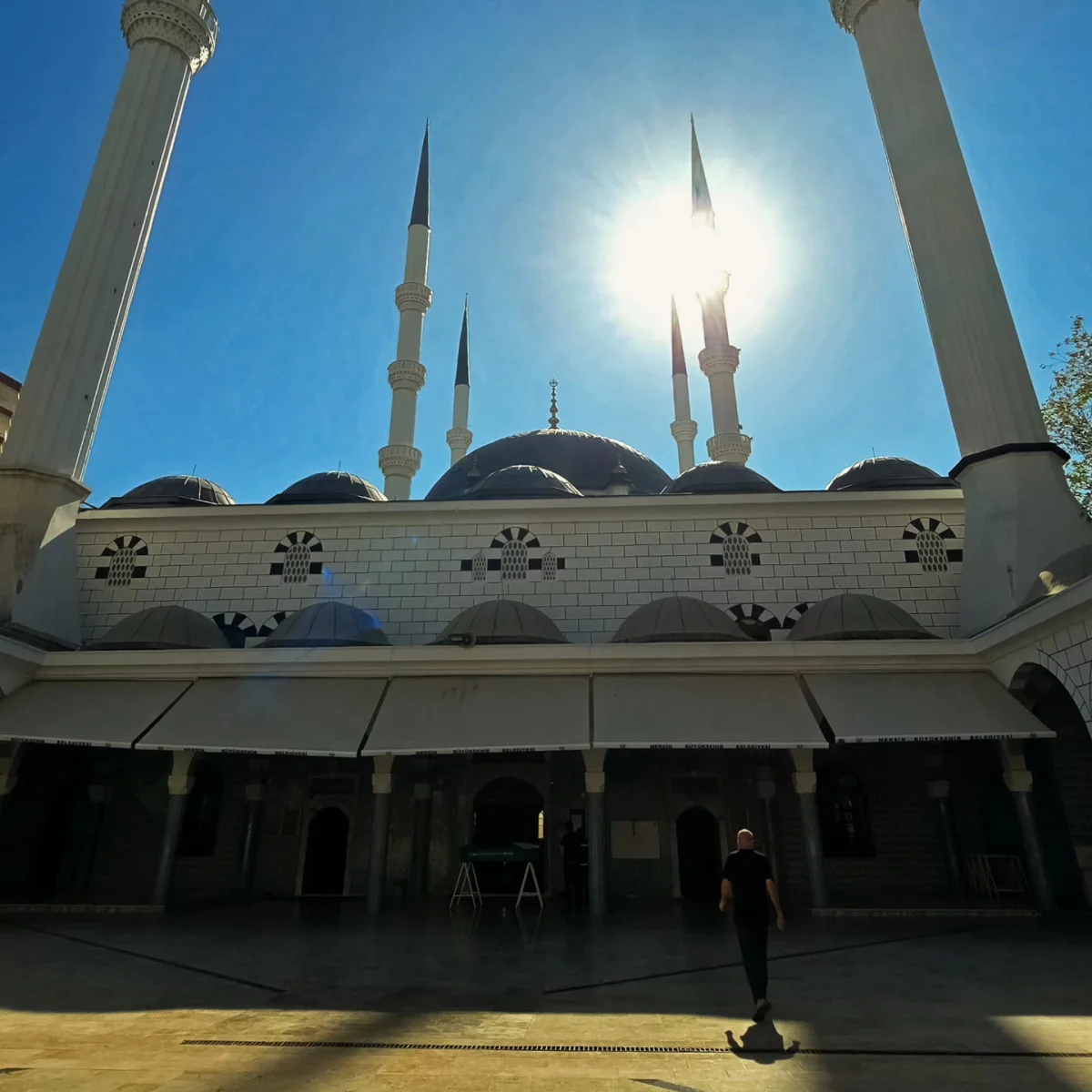 Büyüleyici Mimari Estetik - Muğdat Camii'nin Parlayan Minareleri ve Kubbeleri Yüksek minareler ve büyük kubbeleriyle Muğdat Camii, güneş ışığında parlıyor.