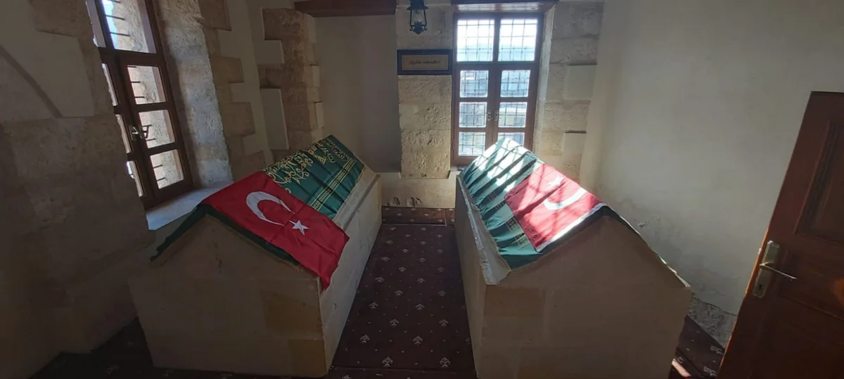 Zeyne Türbesi'nin İç Mekanı - Taş Duvarların Huzuru İki mezarın bulunduğu, taş duvarlı aydınlık bir mekan