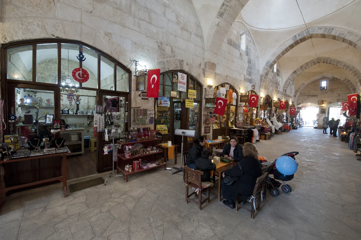 Geleneksel Alışveriş Deneyimi - Kapalı pazarda hediyelik eşyalar ve ziyaretçiler Kapalı pazarda hediyelik eşyalar sergileyen dükkanlar ve ziyaretçiler.