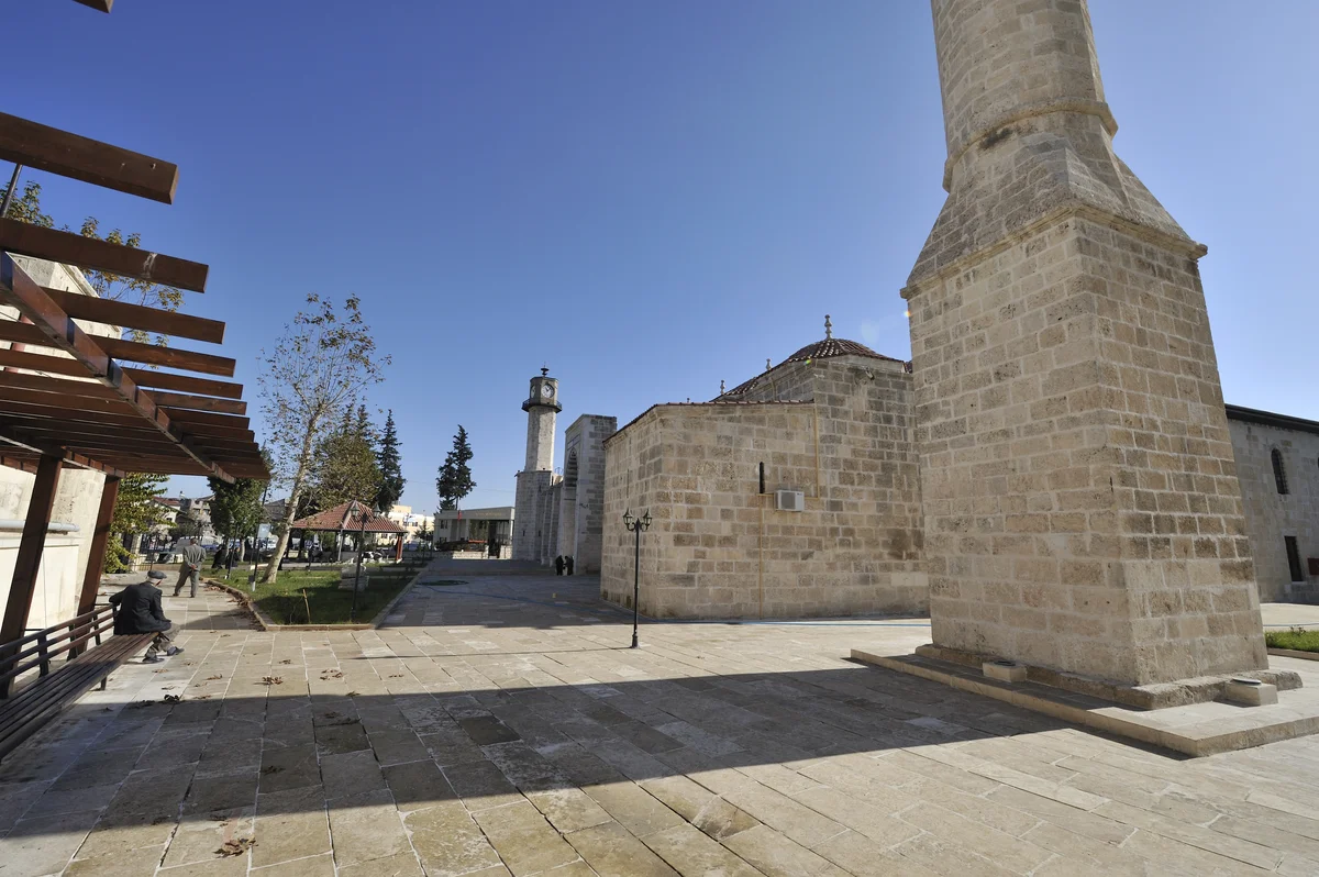 Tarsus Ulu Cami'nin Tarihi Güzellikleri - Ahşap Pergola ve Yeşil Bahçe! Tarsus Ulu Cami'nin çevresi, ahşap pergola ve bank ile yeşil bahçe görünümü.