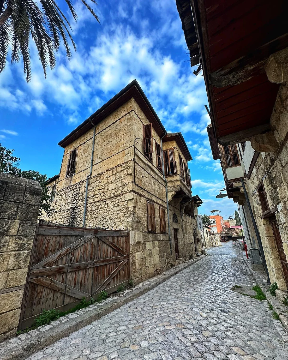 Tarihi Tarsus Evleri - Osmanlı'dan Modern Türkiye'ye Uzanan Bir Mirasın Hikayesi! Tarihi taş binalarla çevrili sakin bir sokak görünümü.