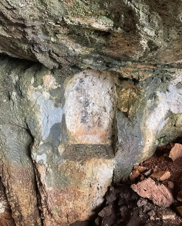 Büyük kaya parçasının altındaki doğal çukurluk ve renk değişimleri dikkat çekiyor.