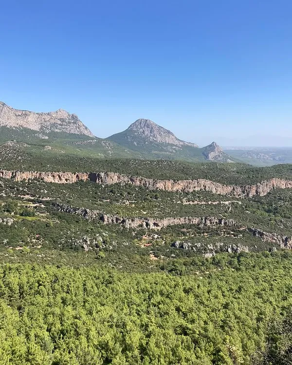 Yemyeşil ormanlar ve aydınlık dağ silsiletleriyle huzur verici bir manzara