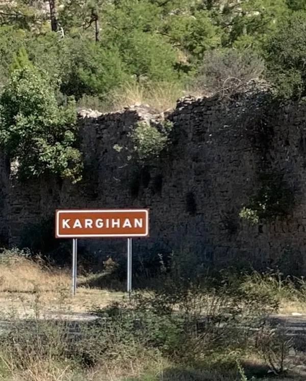 Kargıhan yazılı kahverengi tabela, yeşil ağaçlarla çevrili doğal alanda yer alıyor.