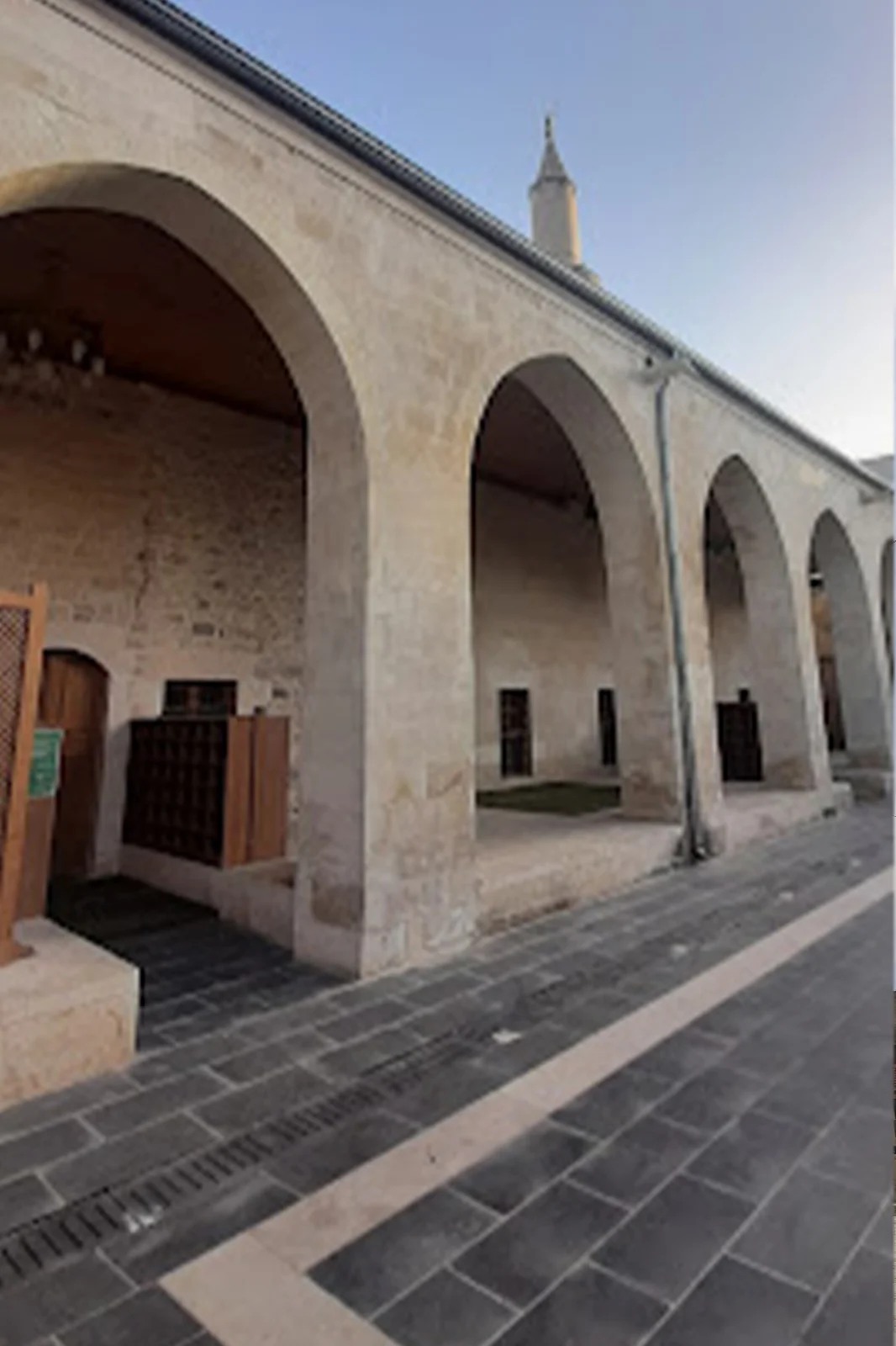 Taş yapı altında büyük kemerler ve minare ile tarihi atmosfer