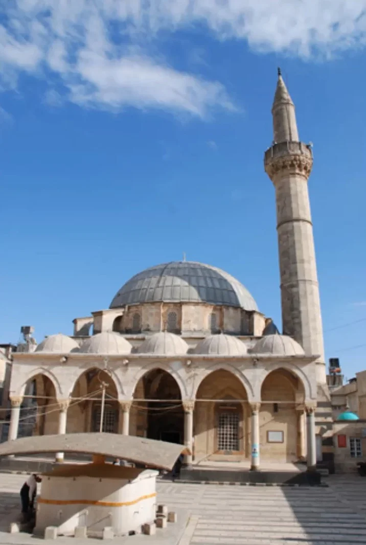 Eski bir cami, yuvarlak kubbe, dörtgen taban ve sütunlu kemerlerle zarif bir mimari yapıya sahip.