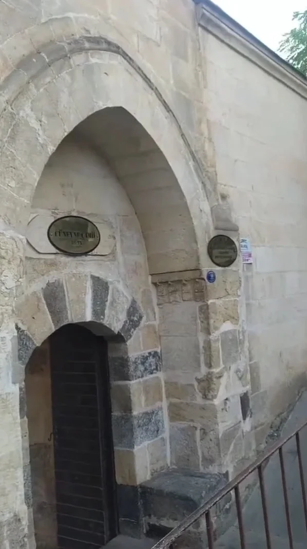 Taş yapılı Cüneyne Camii'nin giriş kısmındaki büyük kemer ve detaylar.