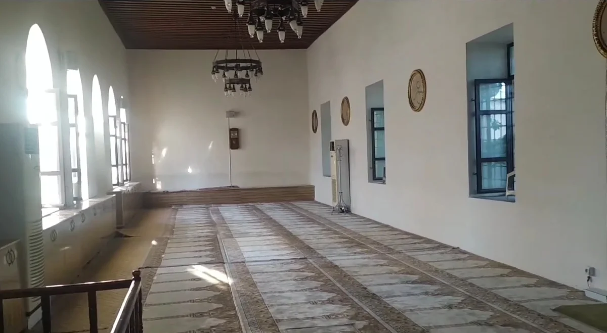 Geniş ve aydınlık iç mekan, klasik avizeler ve desenli halı ile süslenmiş.