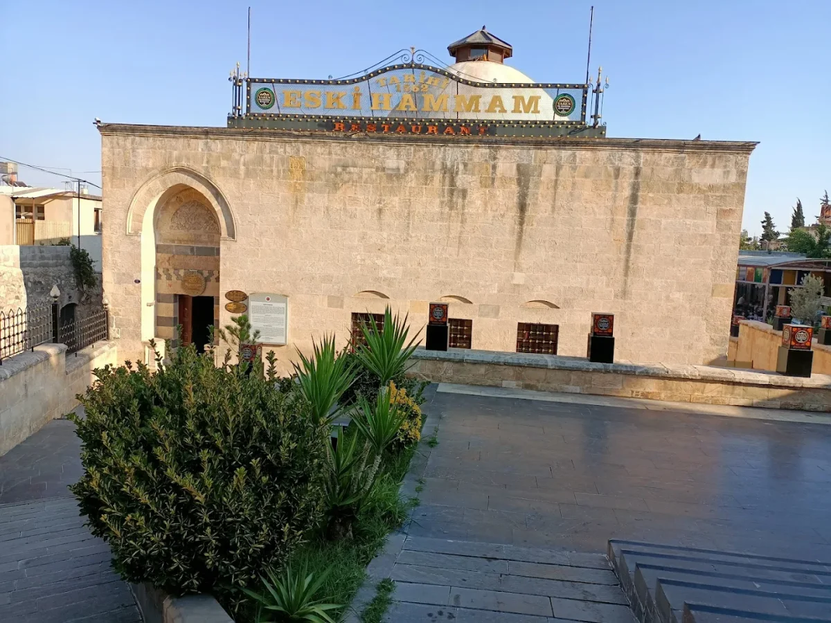 Yeşilliklerle çevrili tarihi Eski Hammam Restoran yapısı, renkli tabelasıyla dikkat çekiyor.