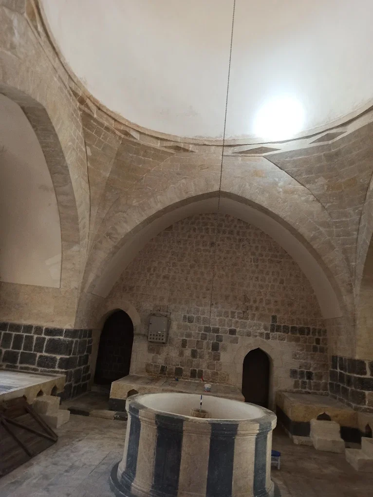 Tarihi Paşa Hamamı'nın iç mekanında yuvarlak çukurluk ve taş duvarlar görünmekte.
