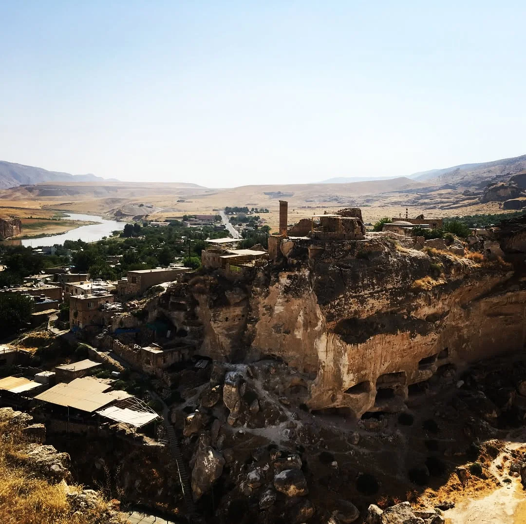 Yüksek kayalığın tepesinden geniş vadiye açılan manzara, Hasankeyf Kalesi'nin kalıntılarını gösteriyor.