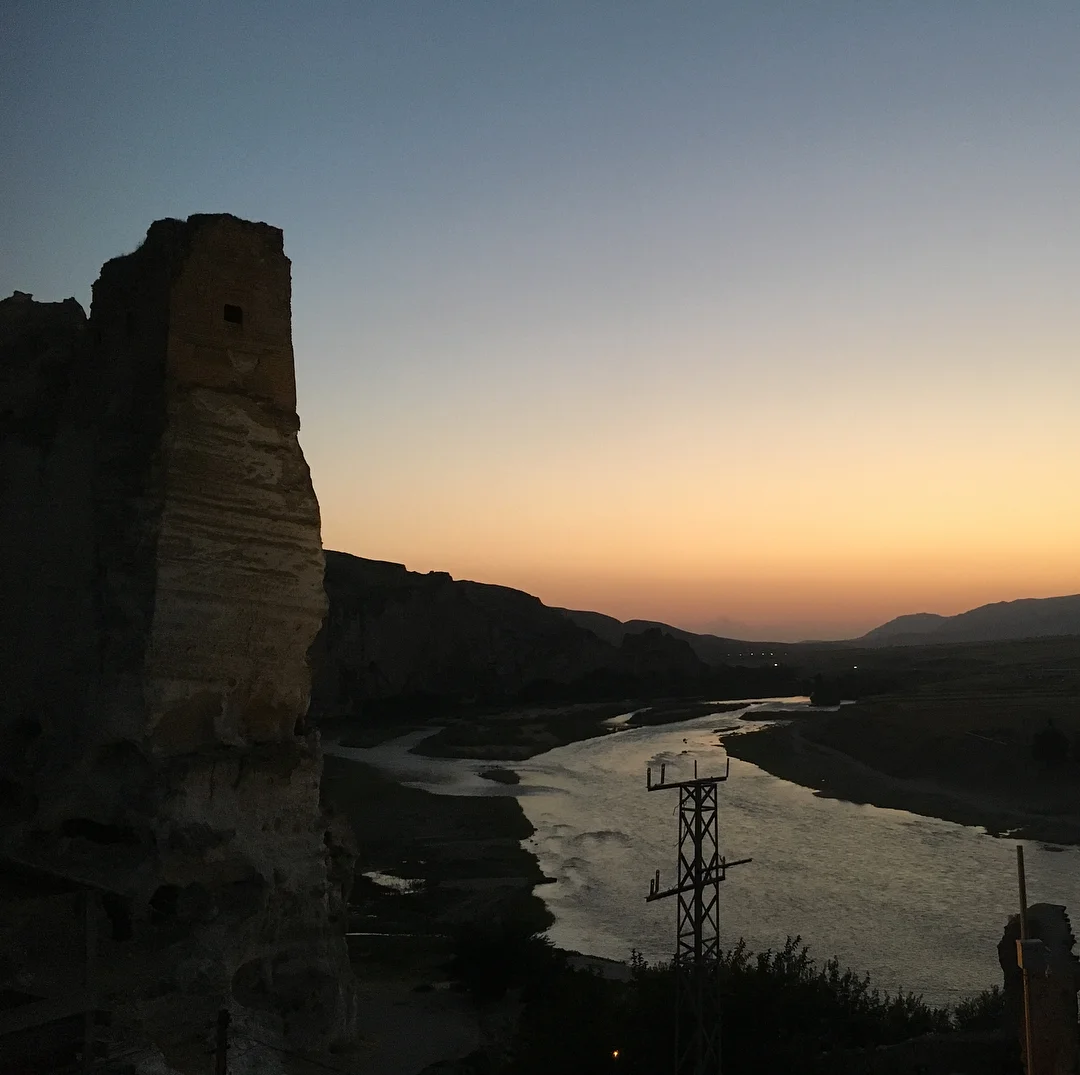 Akşam saatlerinde pastel tonlarda gökyüzü, kayalık oluşum ve kıvrılan nehir manzarası.